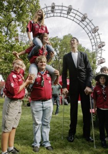 The world's tallest man Kosen poses with scouts in front of Vienna's Giant Wheel landmark